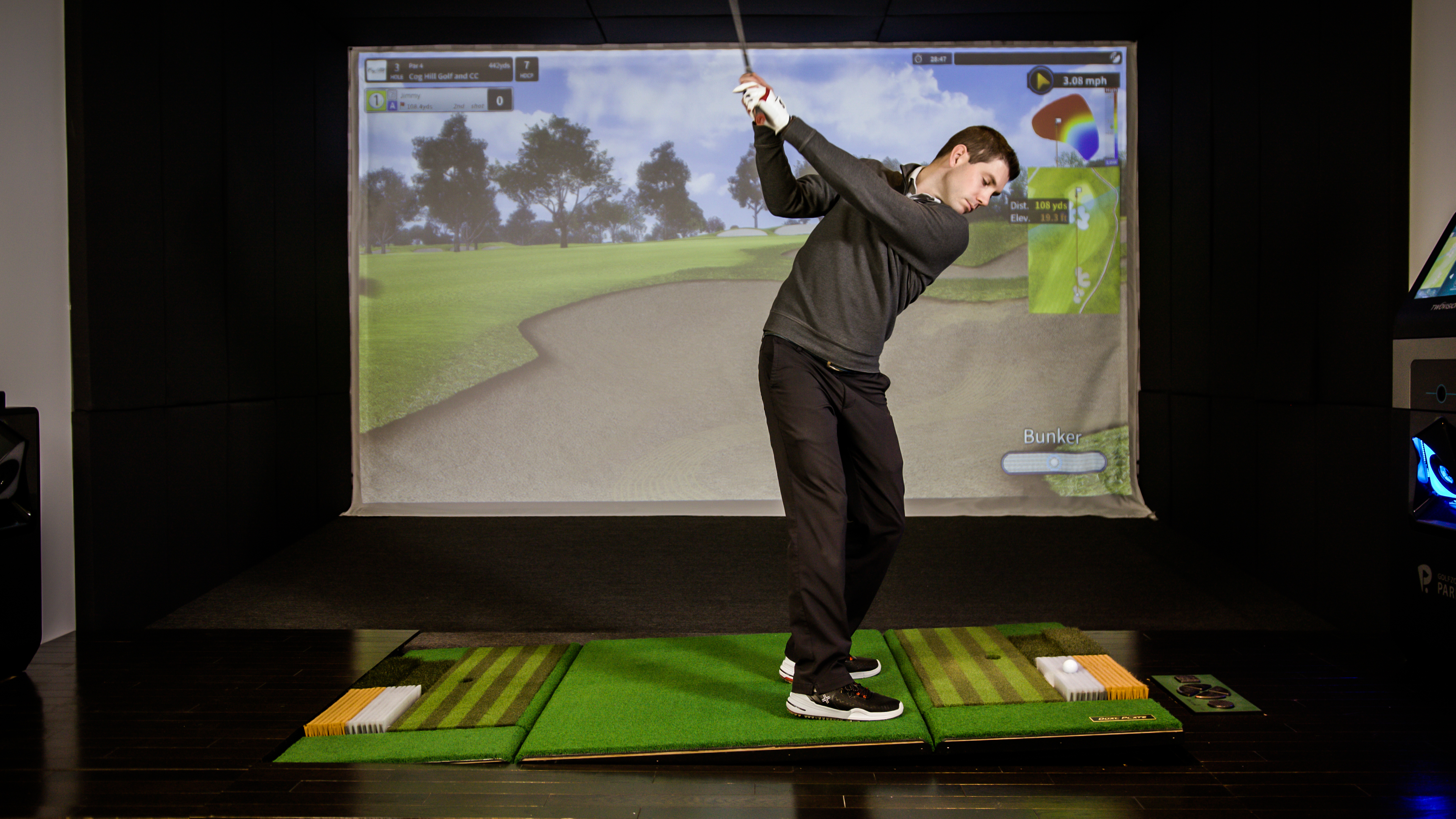 Man swinging golf club for Golfzon’s Twovision golf simulator.